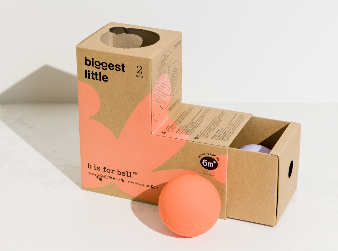 an orange ball shape water toy is out side of its drawer style packaging