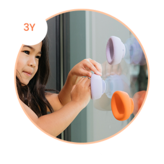 close up of a girl stick 3 b is for ball® on a glass panel showcasing a 3 year old use it for creative play